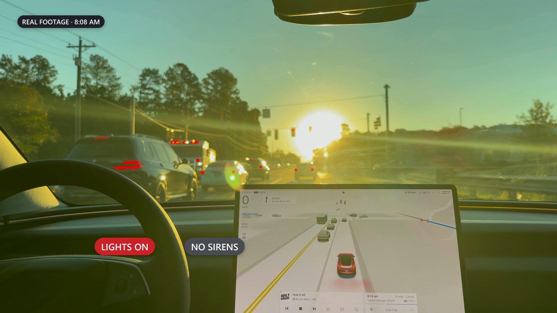 Two fire trucks with their lights on, seen through low sun glare