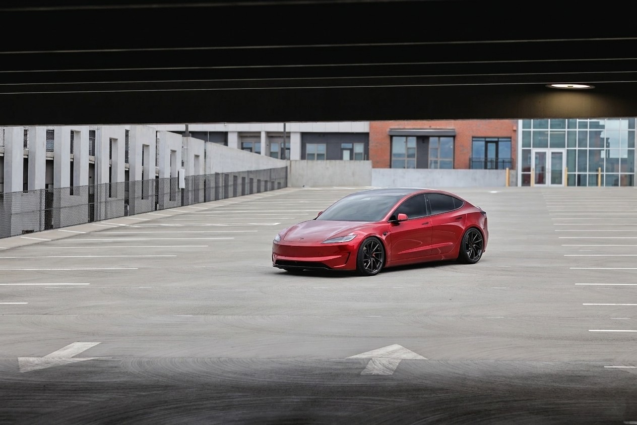 Red Tesla Model 3 Performance on an empty rooftop parking deck